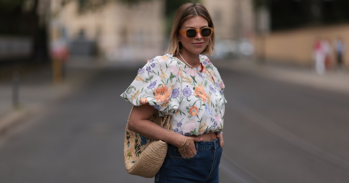 Aline Kaplan wearing Baum & Pferdgarten wide leg blue denim pants, & other stories white flower pattern cropped blouse and orange summer heels and Mango orange black shades on June 06, 2023 in Berlin, Germany.